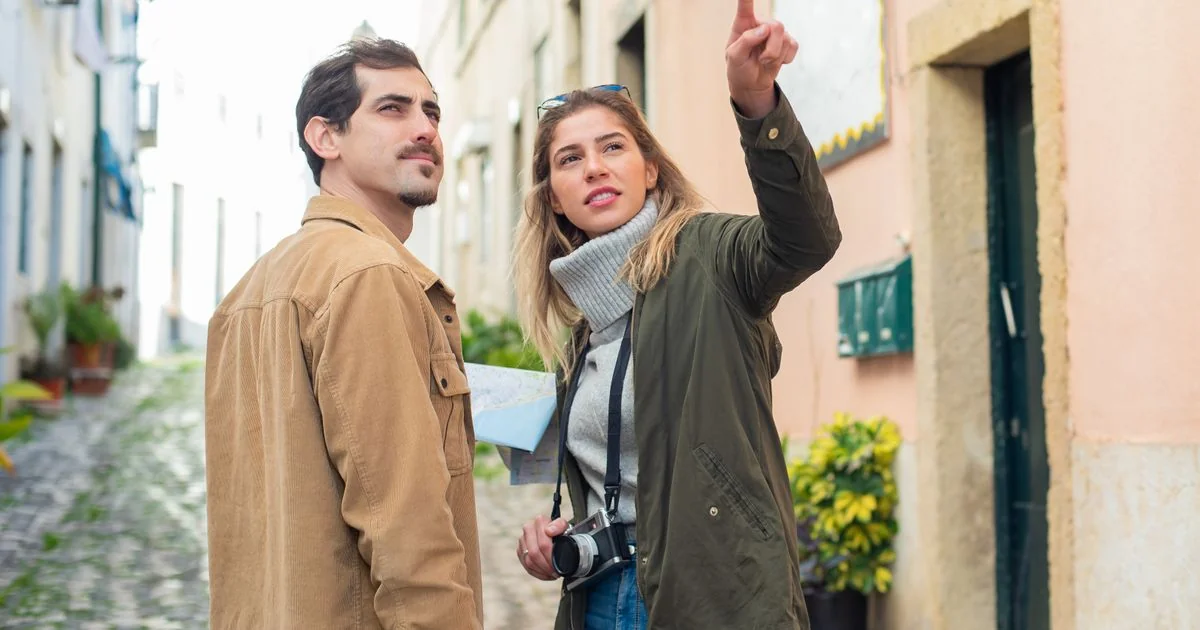 A couple of travellers checking their smartphone on a European street in summer